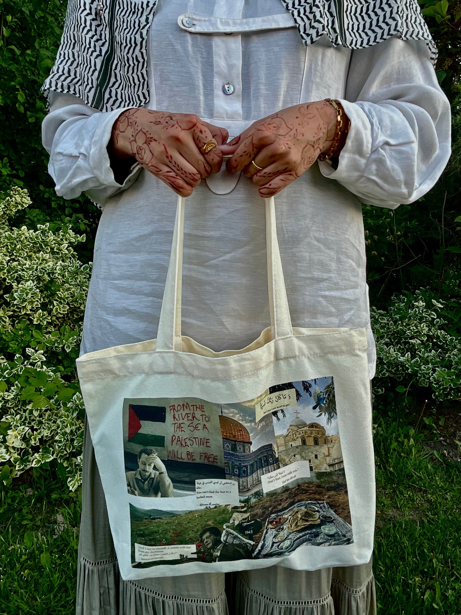 Woman holding a Palestine tote bag with an original collage design in a garden